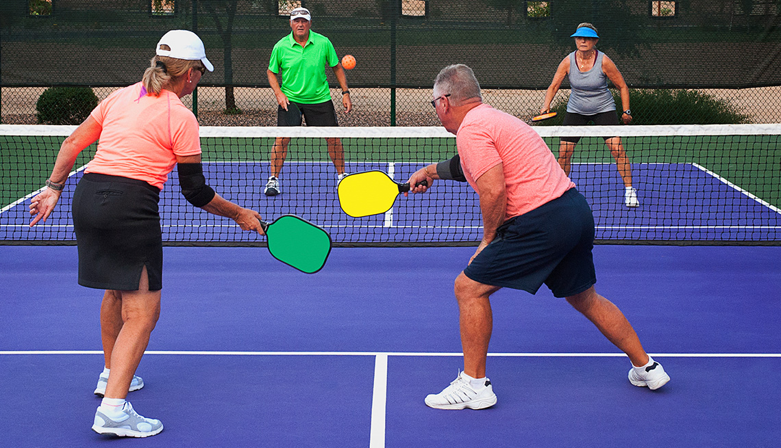 Four older adults playing doubles pickleball on an outdoor court
