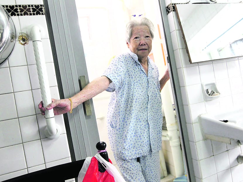 An older resident using a grab bar at the entrance to her HDB bathroom